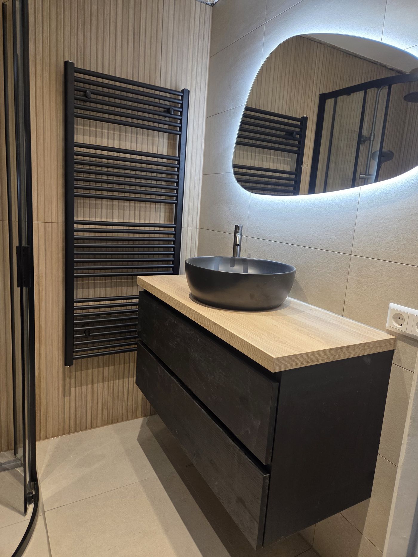 Badkamer met lamellenwand, waskom en eiken meubel