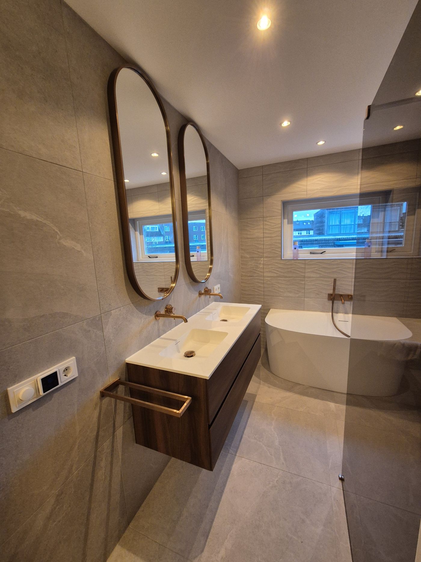 Badkamer met vrijstaand bad en ovale spiegels