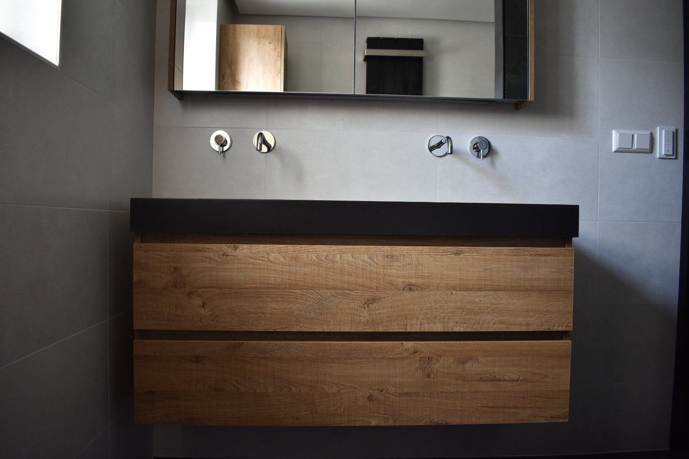 Zwevend eiken badmeubel met inbouwkranen in antraciet wand