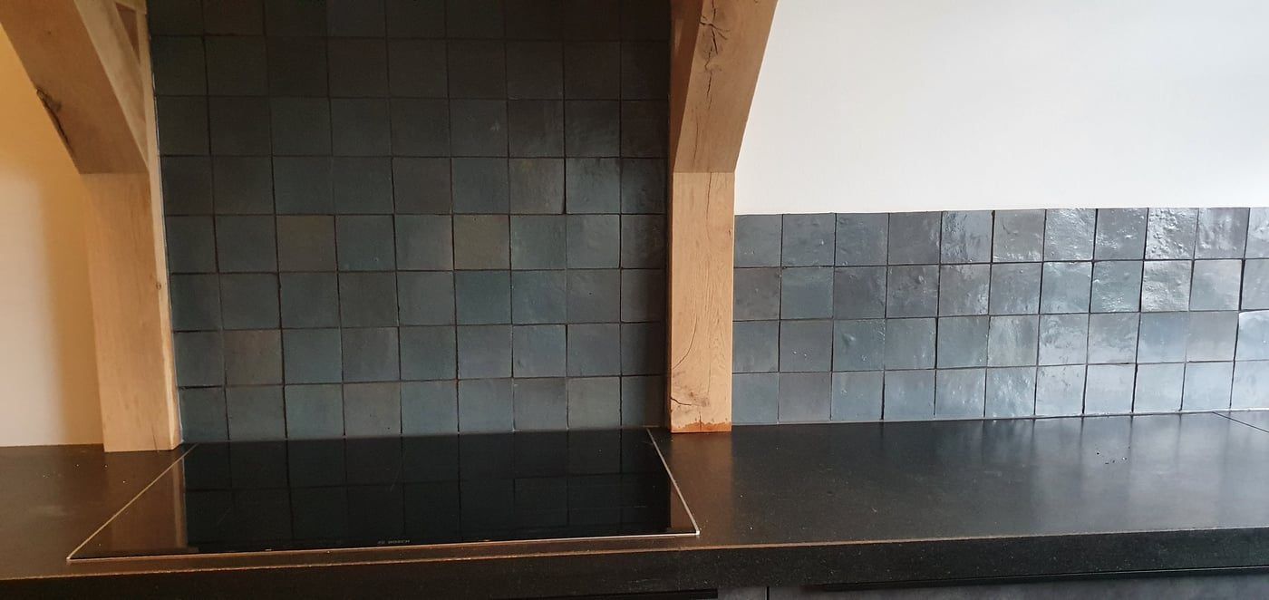 Keukenachterwand met handgemaakte groene tegels en eiken balk