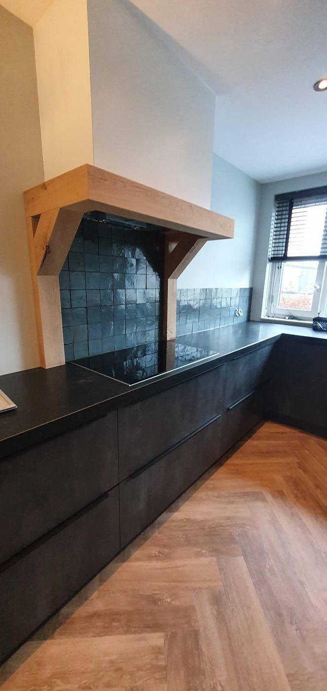 Zwarte keuken met eiken schouw en visgraatvloer