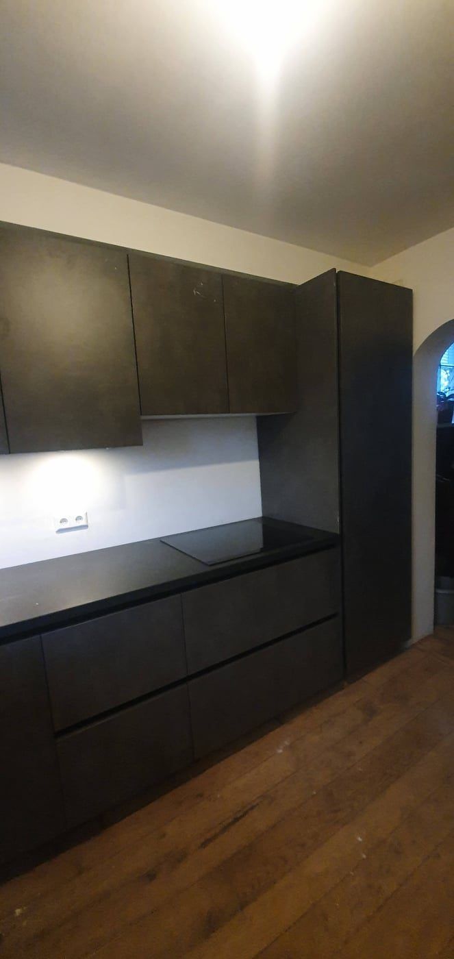 Keukenwand met zwarte fronten en ingebouwde verlichting