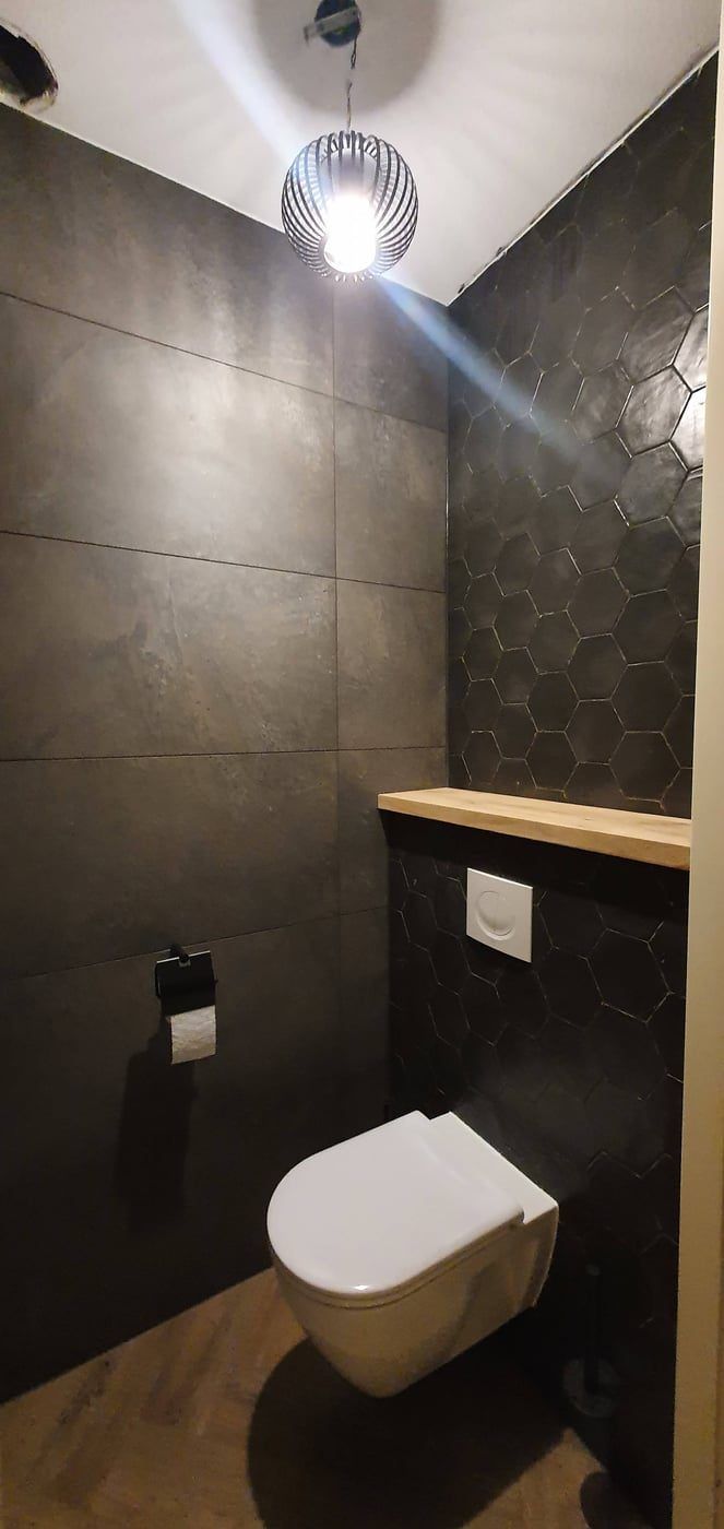 Toiletruimte met hangend toilet en antraciet grootformaat tegels