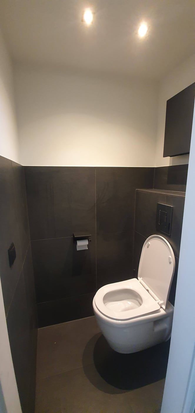 Toiletruimte halfhoog betegeld met hangend toilet