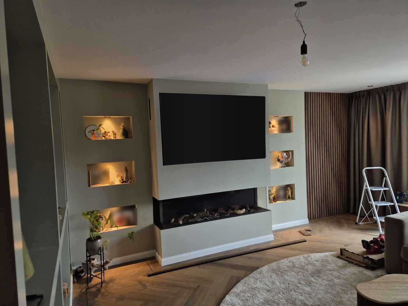 Tv-wand op maat met inbouwhaard en verlichte nissen